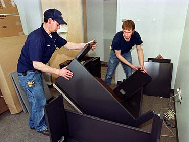 Office movers assembling furniture